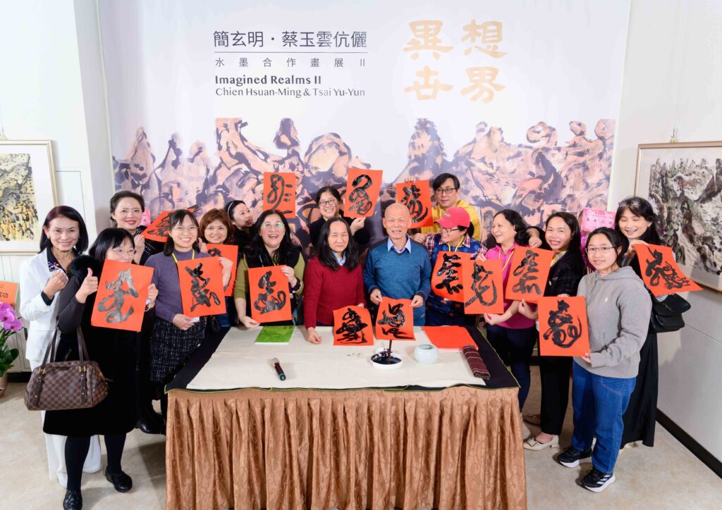▲開幕儀式之後簡玄明老師揮毫寫春聯，送給出席活動的貴賓並合影留念，場面十分熱烈。（記者 辛澎祥/攝）