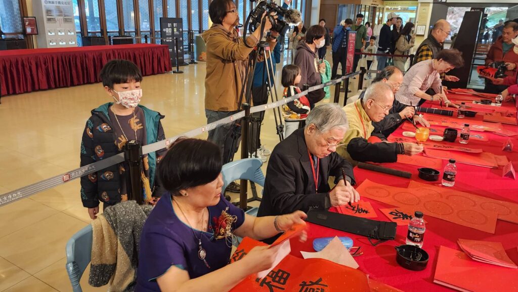 ▲中華書學會的6位書法老師寫春聯，並將完成作品送給民眾，為新的一年營造歡樂氣氛。（記者 辛澎祥/攝）