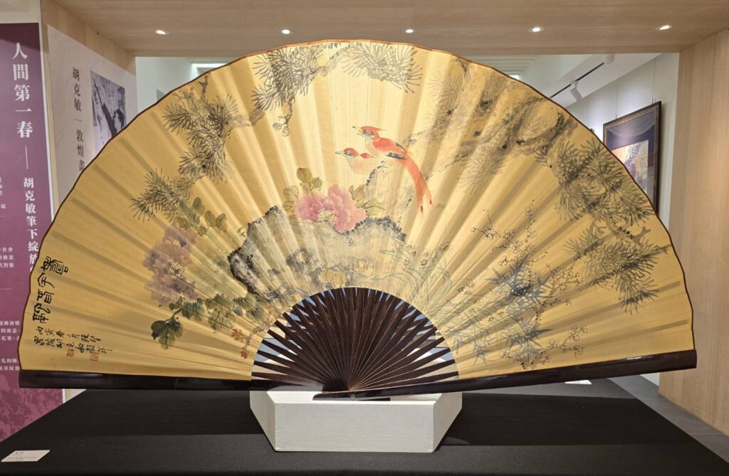 ▲胡克敏老師在大扇面上以「壽宇春融」為題的畫作,讓觀者能自然投入畫境之中,頓顯身心靈愉悅之感。(記者 辛澎祥/攝)