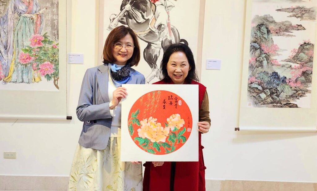 ▲翁小蘭理事長（右）將她所繪的「富貴臨長春至」的牡丹畫作，贈送給新北市文化局局長張䕒育，象徵著國色天香般的富貴安康。（記者 辛澎祥/攝）
