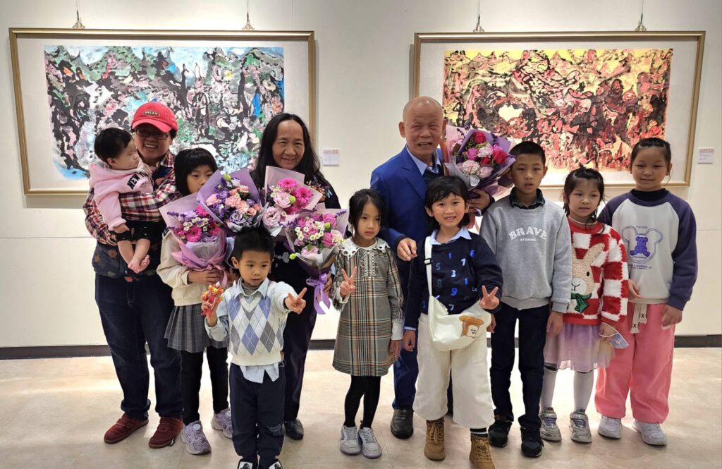 ▲開幕式上，簡玄明與蔡玉雲夫婦的孫子孫女都來會場向他們開展並獻花道賀，場面相當熱烈。（記者 辛澎祥/攝）