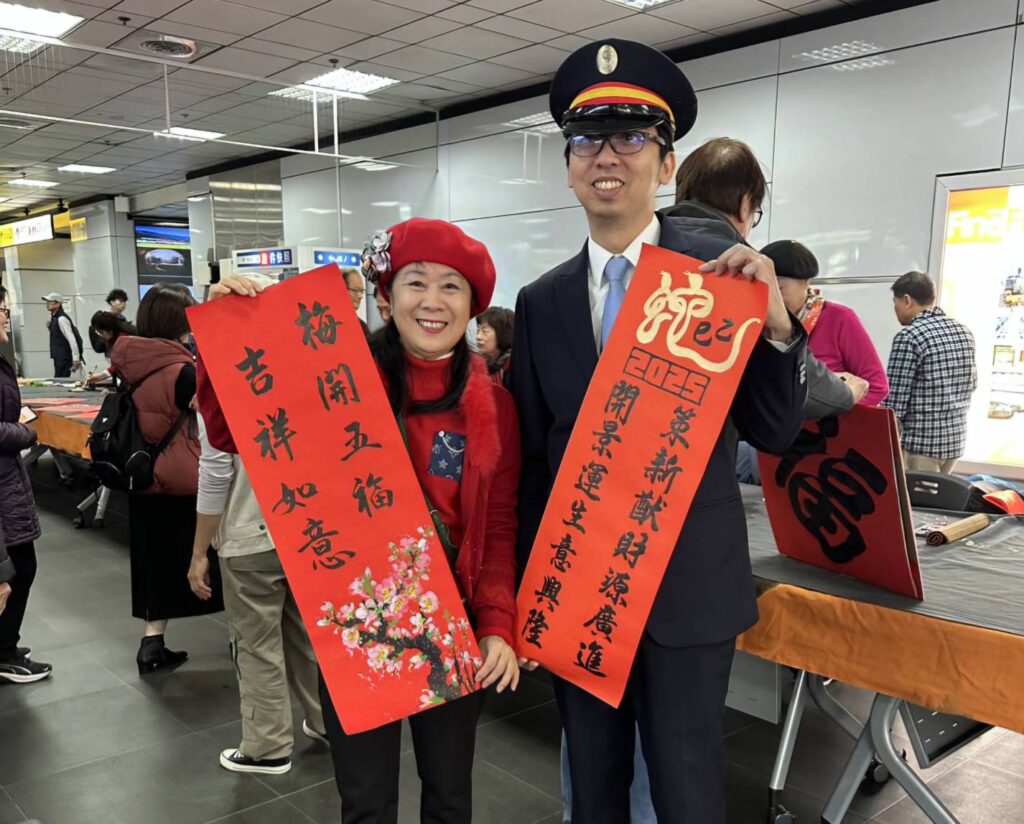 ▲臺鐵台北站站務長林博琛（右）與書畫老師陳月里拿著寫好的春聯開心合影留念。（圖/大媒體新聞網 提供）