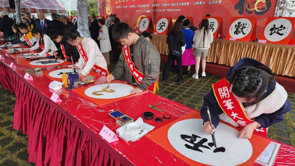 ▲師傳生的同學們也以現場開筆的架式，呈現中華傳統文化文字的豐富美感。（記者 辛澎祥/攝）