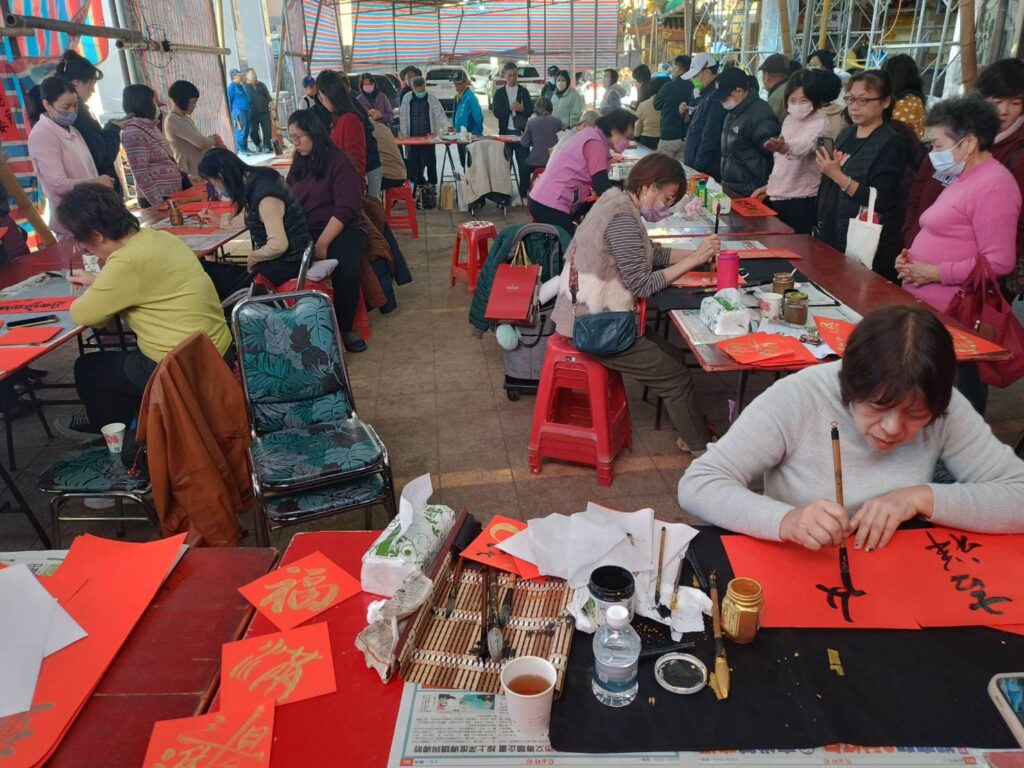 ▲宮廟寫春聯活動是年節重要的文化走春活動之一，帶頭掀起民眾排隊索取春聯的傳承雅興，成為民眾新春期待的樂事。（記者 辛澎祥/攝）