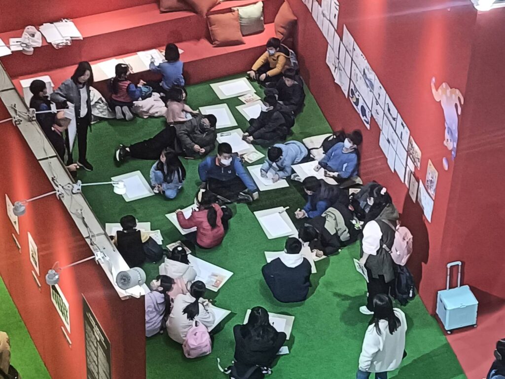 ▲義大利主題國的展攤區吸引了眾多學童前來坐地繪圖，場面熱烈。（記者 辛澎祥/攝）