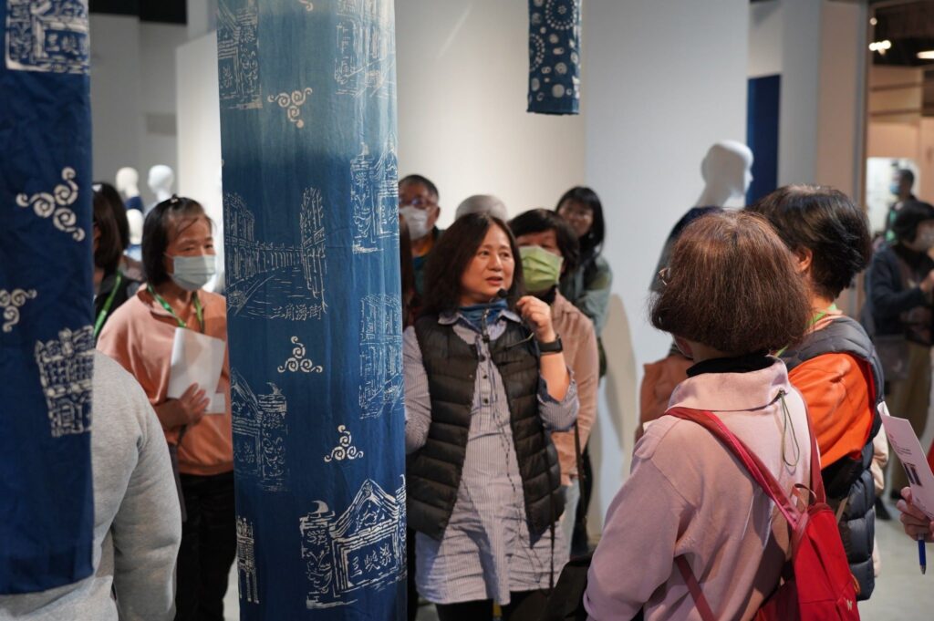 策展人王淑宜(中)解說三峽藍染工藝發展歷史和作品特色。(圖/纖維館提供)