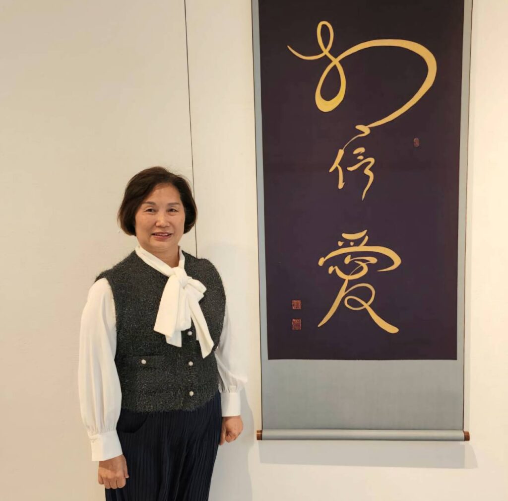 ▲和氣大愛文教基金會董事長段傳芬，在孫端吉教授所闡述的愛與孝作品前留影，對此極具正面意義的展覽賦予高度期待。（記者 辛澎祥/攝）