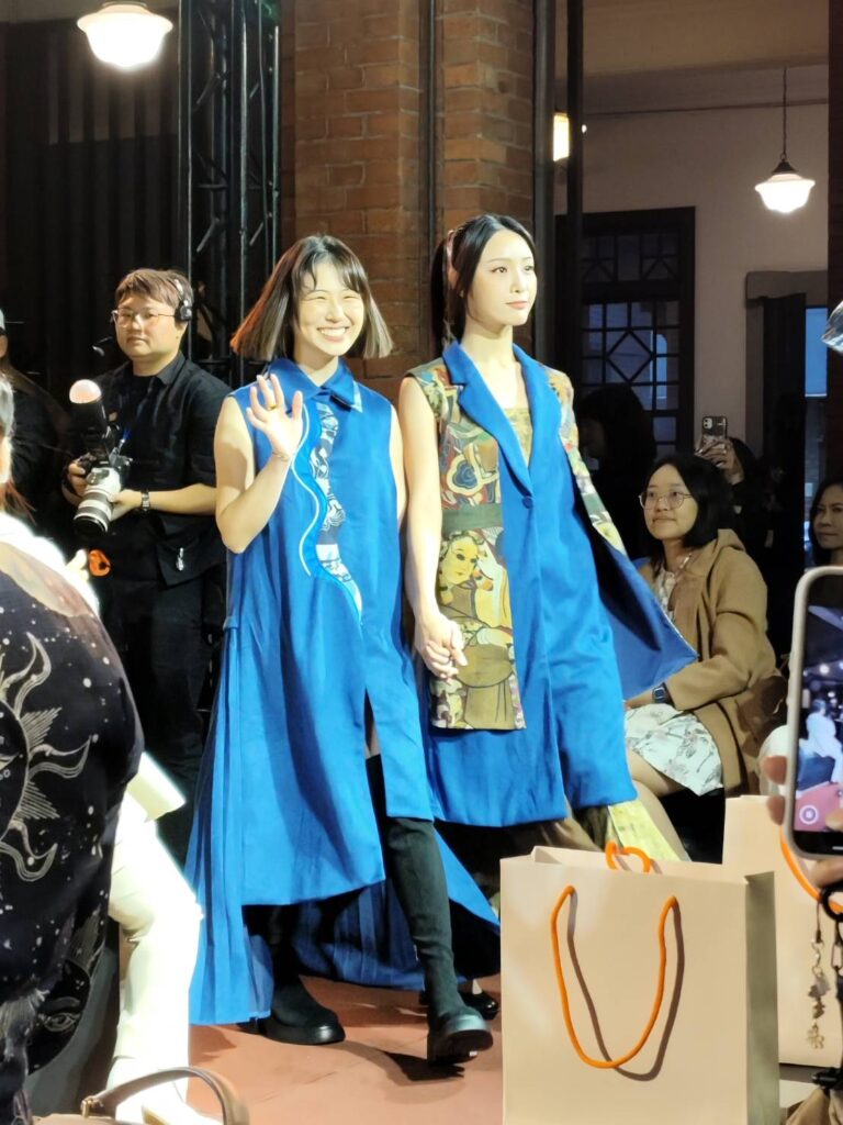 青年設計師以史博館12件館藏圖像為靈感， 讓「NCA時尚秀」充滿驚喜，左為亞藝文創協會執行長王贒勲穿著以《新莽大泉五十銅範》為主題演繹的拼接長版上衣。（記者 陳安婷/攝）