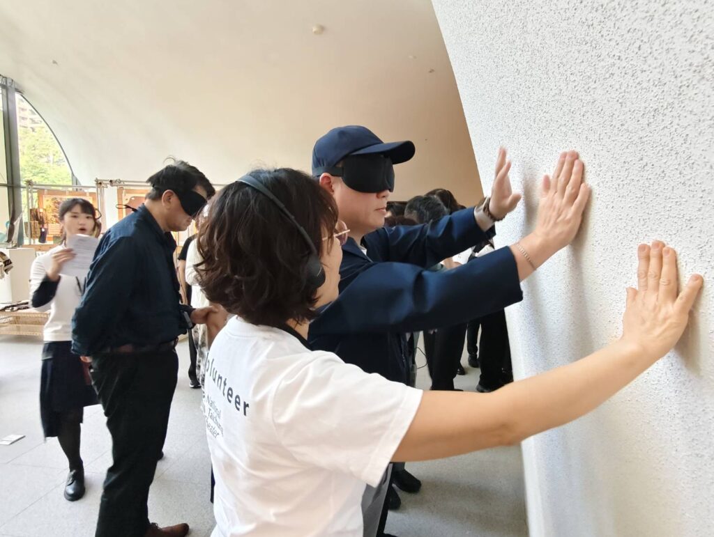 歌劇院友善服務從建築導覽為起點，志工帶領民眾以手觸摸牆壁用心感受。（記者 陳安婷/攝）