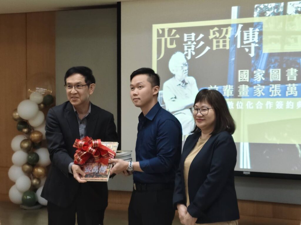 張萬傳家屬黃秋菊女士（右）及張民立先生（中）致贈國圖的張萬傳主題圖書，由翁誌聰副館長代表接受。（記者 陳安婷/攝）