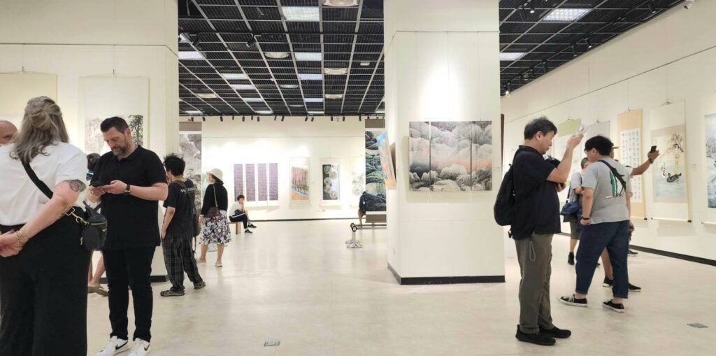 ▲國內外遊客與民眾在1日開展首日即在展場欣賞聯展作品，場面熱烈。（記者 辛澎祥/攝）