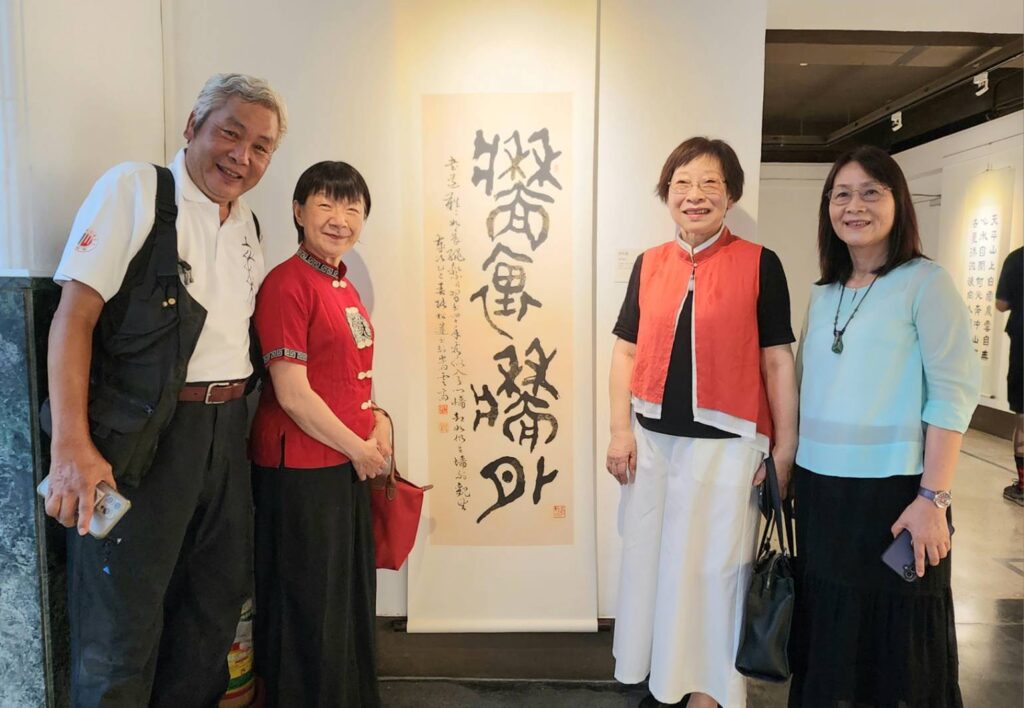▲女書法家張松蓮老師（右二）與多位書家在她展出的作品前合影。左二為一德書會會長蔡玉雲老師。（記者 辛澎祥/攝）