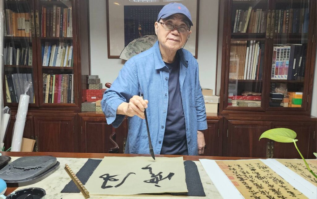 ▲信手寫下「風雲」二字，施春茂老師只要提筆，就顯得神情格外愉悅。（記者 辛澎祥/攝）