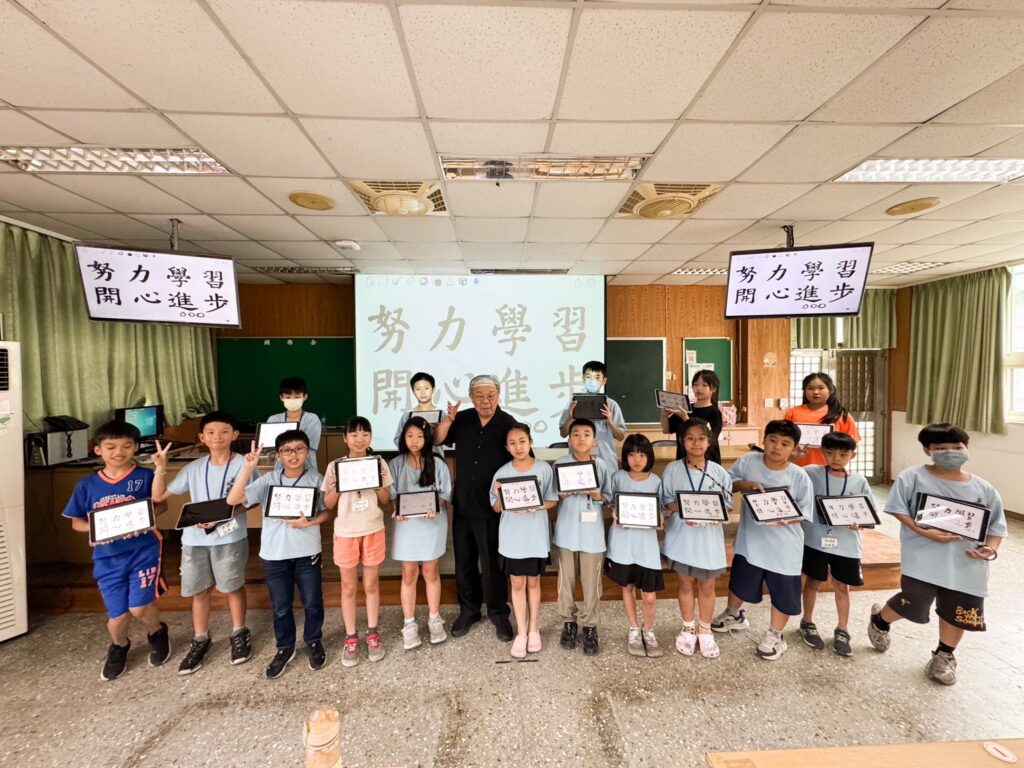 ▲張炳煌教授（中）與參加e筆書法研習的同學們持作品合影留念。（圖/張炳煌 提供）