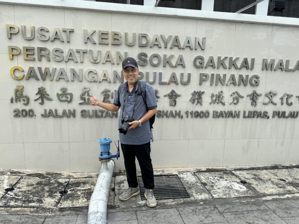 ▲參家雙城水彩畫交流展的臺灣參展藝術家劉達志老師,在展場入口處留下紀念照。(圖/劉達治 提供)