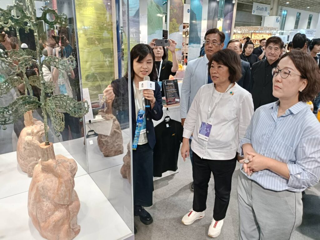 ▲中央與地方首長對國立歷史博物館的跨業合作的商品極有興趣,館方導覽人員也逐一介紹商品的特性與藝術價值。(記者 辛澎祥/攝)