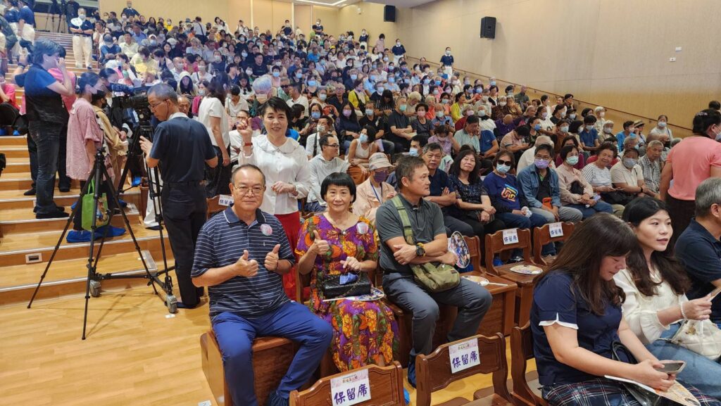 ▲簡文秀在觀眾席上比出愛心，向民眾祈福，神情顯得相當愉快。（記者 辛澎祥/攝）