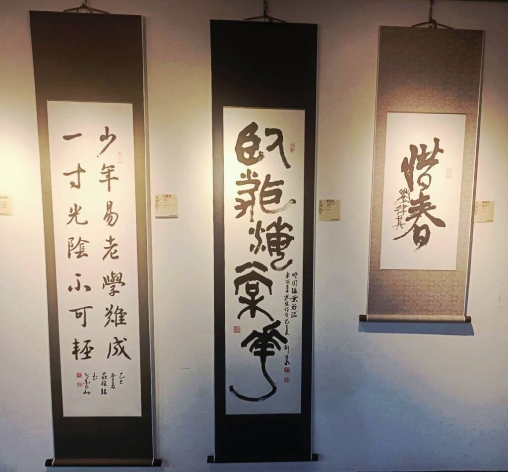 ▲展出中有三位跟著曹靜琍老師學習書法的未成年養成會員作品展出，左起莊馥銘（大一學生）、劉泫承（國中二年級）及劉律其（國小二年級），展現其紮實的根基，成為展場矚目的焦點。（記者 詹佳綺/攝）