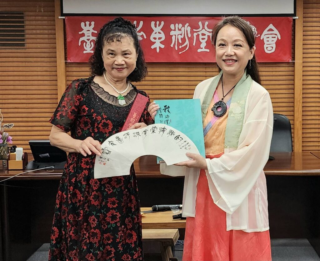▲開場演奏古琴樂曲的陳麗如老師（右）接受曹靜琍理事長致贈書冊與書藝小品，兩人開心合影留念。（記者 詹佳綺/攝）