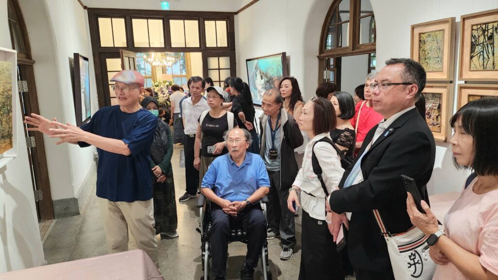 ▲郭博州教授（左）為貴賓進行作品導覽，中為前北、高美術館館長黃才郎，大家專注聆賞，場面熱烈。（記者 詹佳綺/攝）