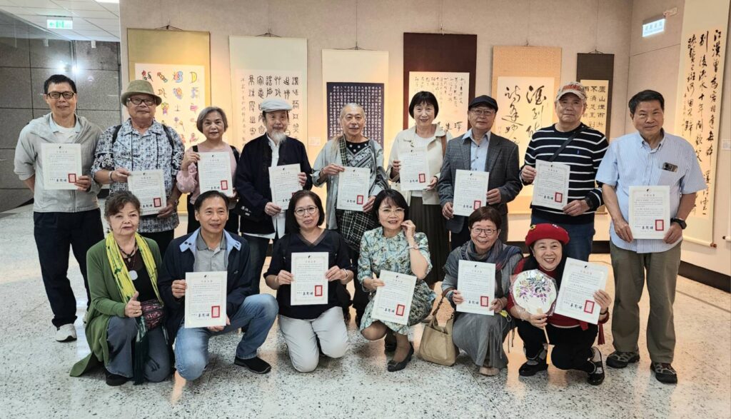 ▲出席開幕式的協會參展藝術家開心的持參展證書合影留念。（記者 詹佳綺/攝）