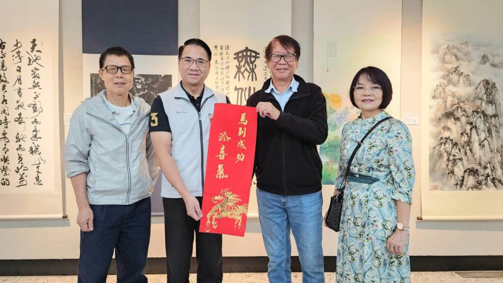 ▲協會林加添老師（左一）的書法，加上江玉瑞老師（右一）所繪畫的金馬，讓這幅「馬到成功添喜氣」春聯作品，由協會理事長辛澎祥（右二）代表贈送給桃園文化局唐連成副局長（左二）並合影留念。（記者 詹佳綺/攝）