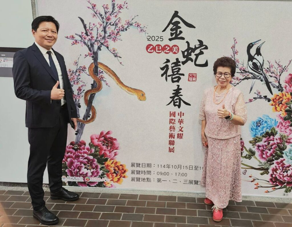 ▲新北市副市長朱惕之（左）與中華文耀創會理事長呂玉環在展覽主視覺暨呂玉環的彩墨作品前合影，神情相當愉快。（記者 詹佳綺/攝）