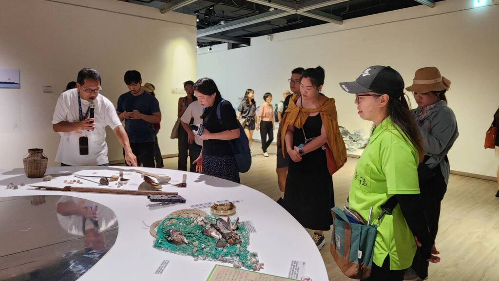 ▲馬祖國際藝術島專案辦公室執行秘書陳其平(左)向觀展民眾說明展區五大主題作品的特色與由來。(記者 辛澎祥/攝)