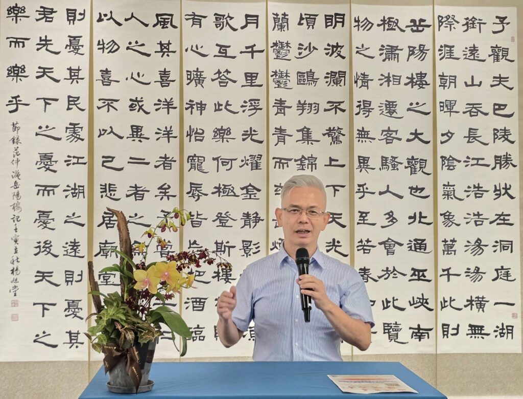 ▲中華書道學會理事長楊旭堂強調這次展出有很多的特色與亮點，對提昇觀賞者的心境有正面的助益。背後作品即是楊旭堂理事長的6聯屏精彩創作。（記者 詹佳綺/攝）