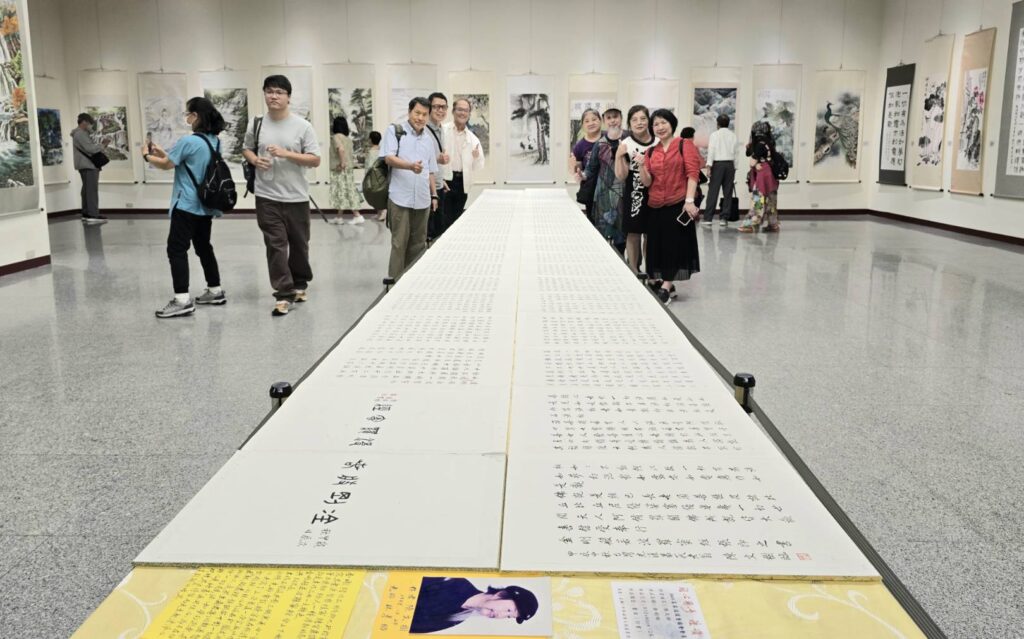 ▲書法家陳文樹老師(右三)以書寫金剛經經文之書冊作品成為展場的展出亮點,備受好評。(記者 詹佳綺/攝)