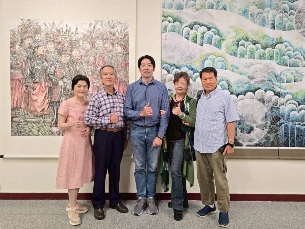 ▲水墨畫家黃中泰老師(中)以原民人物的細膩描繪見長,與多位水墨畫老師們在展場合影留念,左後方為其展出作品,頗為吸睛。(記者 詹佳綺/攝)