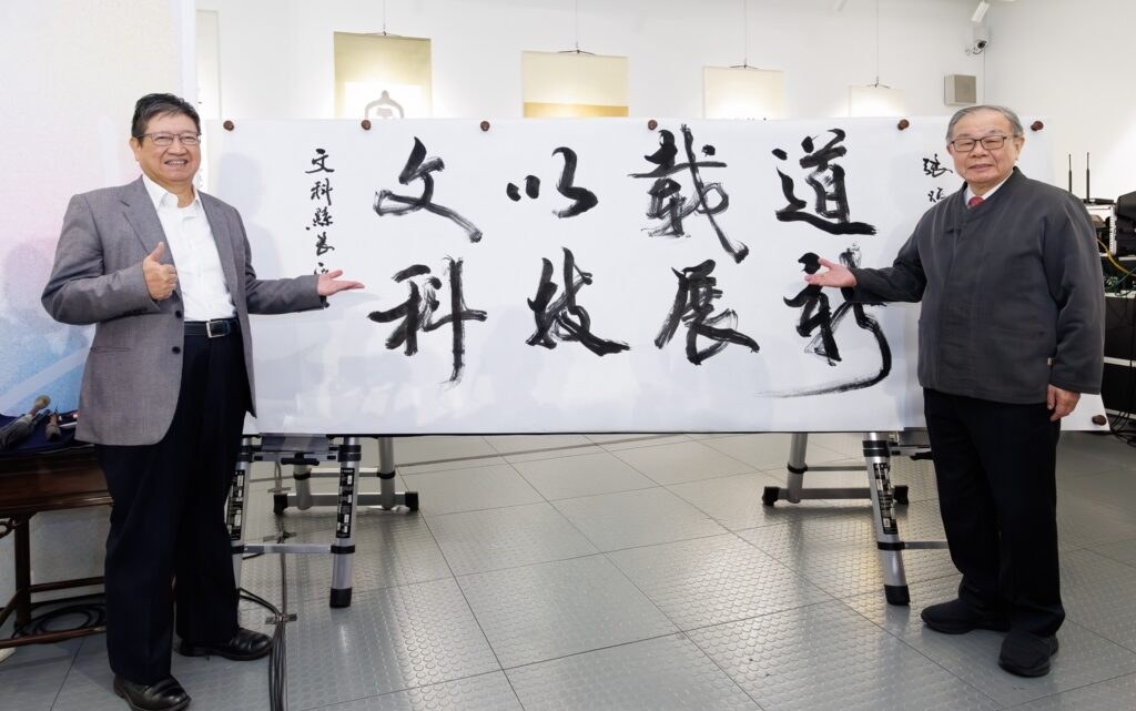 ▲新竹縣縣長楊文科(左)特別出席書法家張炳煌教授書法個展開幕式,張炳煌教授特別書寫「文以載道 科技展新」墨寶增送給楊文科縣長。(圖/張炳煌 提供)
