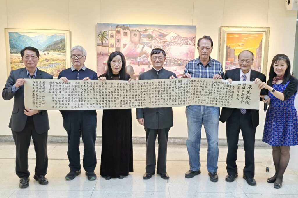 ▲前文建會副主委洪慶峰(中)特別書寫長卷墨寶贈送給曾淑慧老師(左三),並與開幕式貴賓合影留念,場面熱烈,溫馨感人。(記者 詹佳綺/攝)