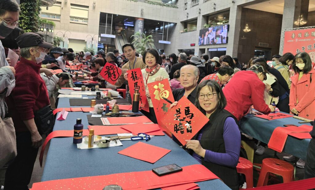 ▲馬年行大運，書會負責人親自出馬寫下馬年吉祥話，讓書寫春聯成為現場民眾索取的焦點，歡樂場面持續到最後。（記者 詹佳綺/攝）