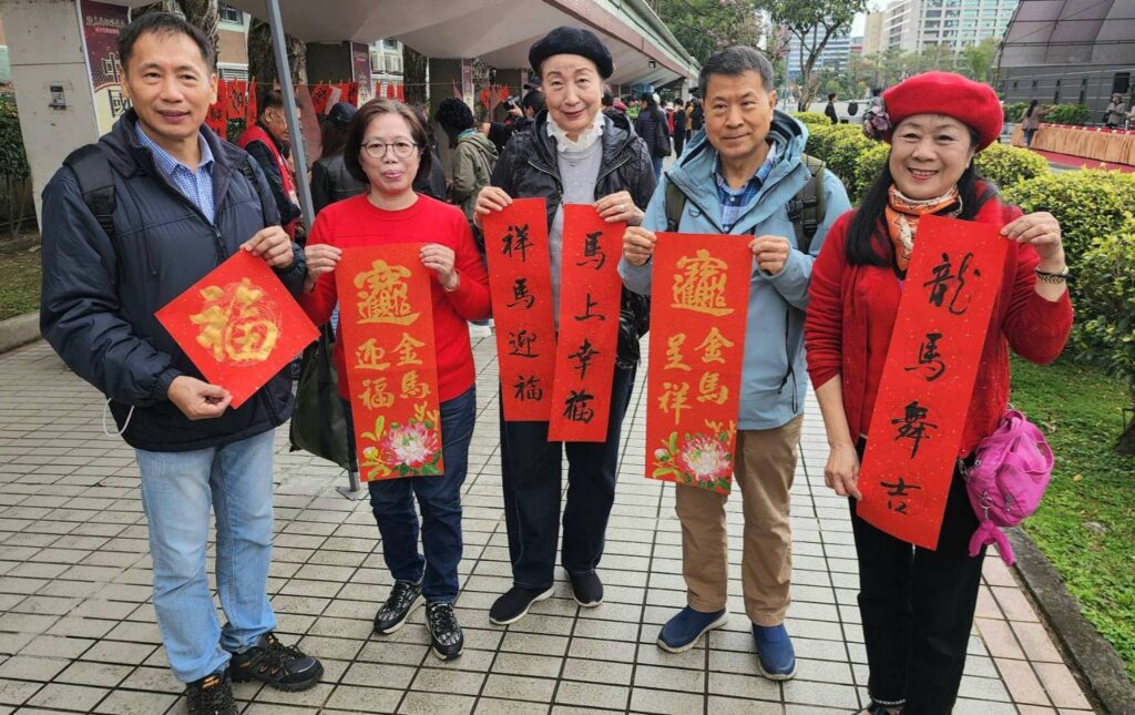 ▲中華娛樂文創產業發展協會的書畫老師們精心撰寫春聯送給民眾，受到高度的歡迎。（記者 詹佳綺/攝）