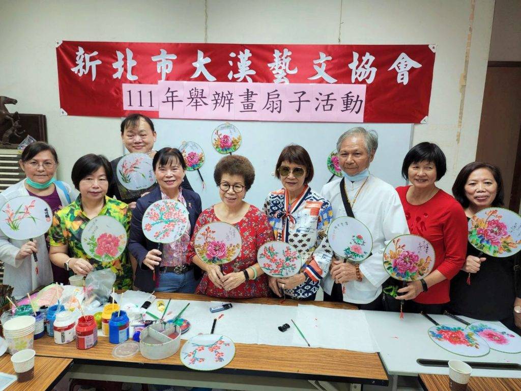 ▲擔任台北市大漢藝文協會理事長時期的呂玉環（中）經常舉辦年節前的畫扇子活動，場面熱烈。（圖/本社資料照）