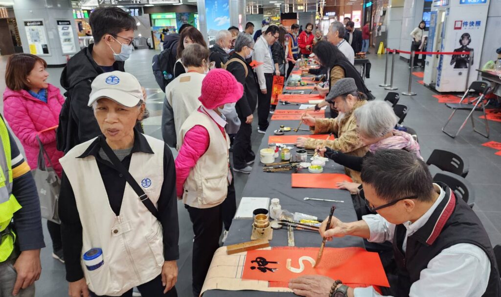 ▲協會書畫老師在寫春聯賀新年活動及呈現馬年在新春之始，所帶給民眾歡樂氣氛，提昇了臺鐵在文化推廣上的正面效益。（圖/大媒體新聞網 提供）