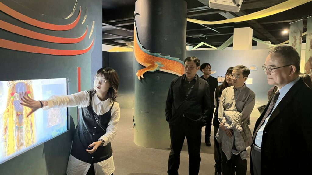▲故宮博物院院長蕭宗煌(右)在松山奉天宮聽取數位展的導覽。(圖/故宮 提供)