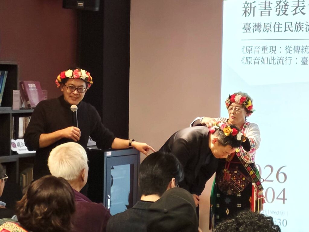 吳花枝（右）親手為計畫主持人暨主編黃國超（左）及其助理戴上原住民花環。（記者 陳安婷/攝）