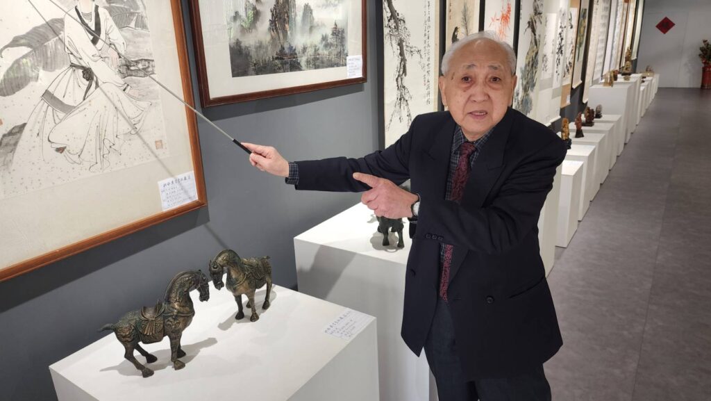 ▲洪啟義老師為到訪的貴賓們，進行他書畫作品的導覽，詳實且深刻，帶給觀者有資訊全面的掌握。（記者 辛澎祥/攝）