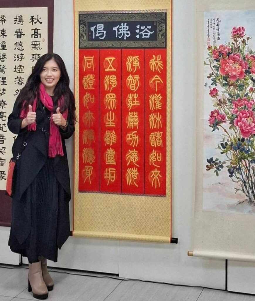▲新北市大漢藝文協會理事長潘珮君，在她以篆體所書寫的作品「浴佛偈」，文詞優美，筆觸深邃且讓人視野遼闊般的殊勝沈靜。（記者 詹佳綺/攝）