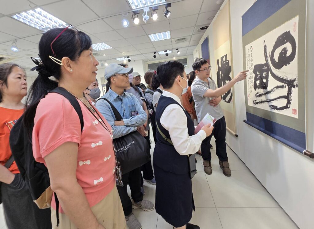 ▲主辦單位特別在開幕式後為出席活動貴賓進行作品導覽,場面熱烈。(記者 詹佳綺/攝)