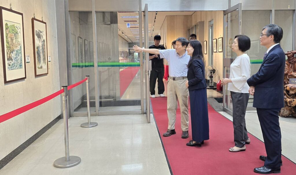 ▲廖仁彬(左)在開幕式後上為土地銀行高層主管進行作品導覽,左二起土銀副總經理蔡慈瑛、主任秘書鄭瑟琴與秘書處處長程權勝,導覽專注的神情讓觀者如同進入其作品畫境之中。(記者 詹佳綺/攝)