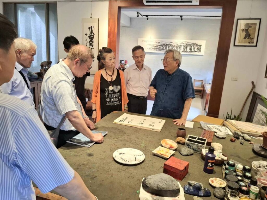 ▲潮音小築的主人林永發教授(右)在北東藝術家交流聯誼會上,與揮毫的老師們暢談落實藝術生活美學的重要性。(記者 詹佳綺/攝)
