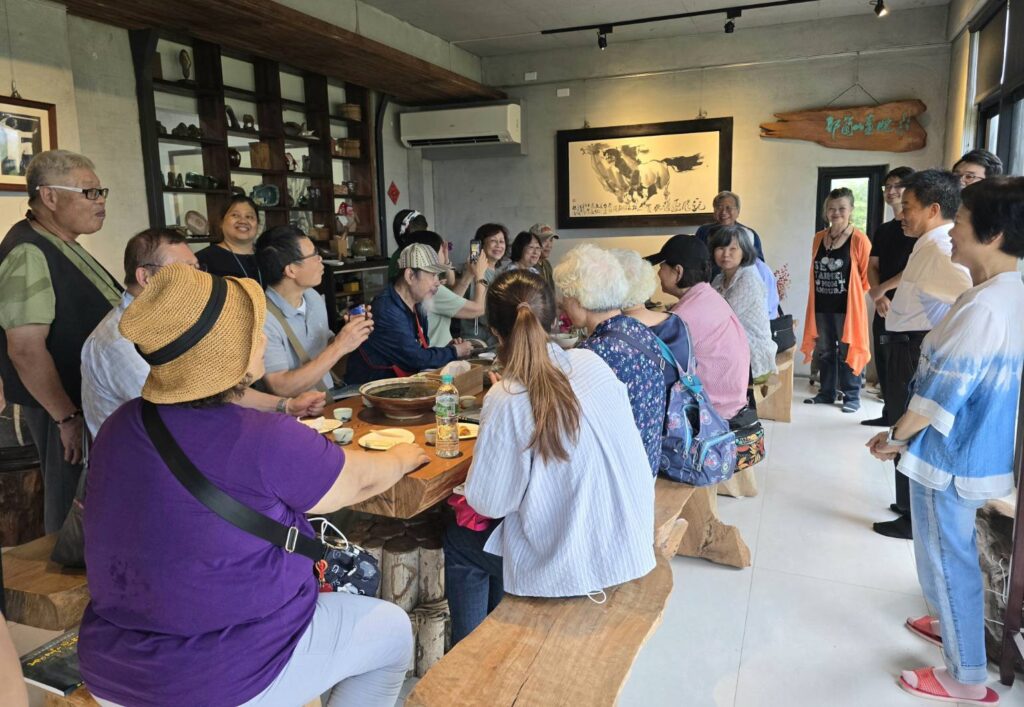 ▲林永發教授(後中)為北東兩地藝術家們介紹潮音小築的由來與展現的在地文化風雅與特色,令與會者聽得津津有味。(記者 詹佳綺/攝)