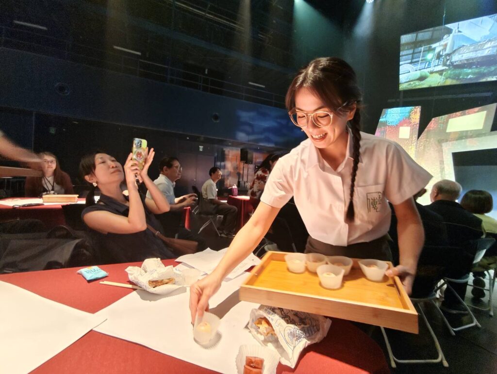 看劇時，還會為觀眾呈上代表士林當地美味的糕餅。（記者 陳安婷/攝）