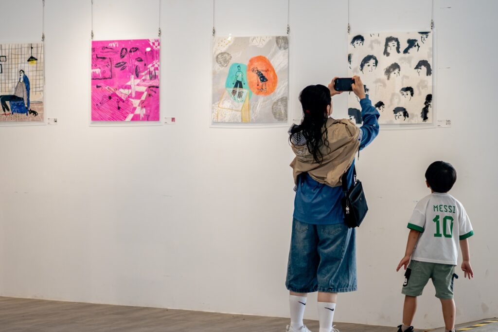 《紙上城市插畫展》吸引民眾觀展側拍。(圖/中原文創園區提供)