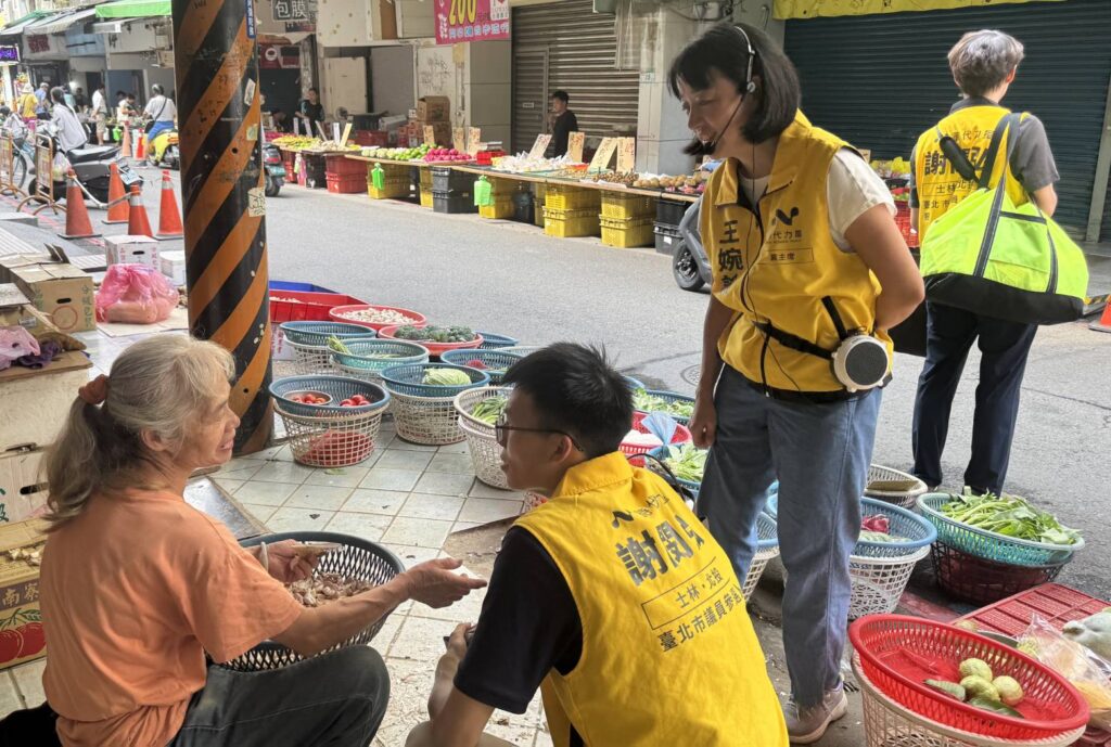 ▲在士林市場擺攤賣菜的業主,認為年輕人投身政治活動沒有包袱,並鼓勵與支持謝閔弘(中)勇於參選,無所畏懼。(圖/謝閔弘團隊 提供)